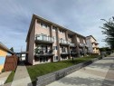 Stucco exterior with multiple private balconies featuring glass railings - #209 11429 124 St Nw, Edmonton, AB 