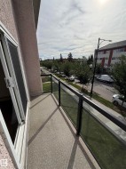 Private balcony featuring a textured concrete surface and glass panel railing - 