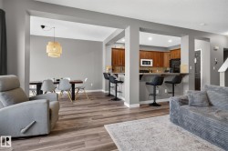 Open-concept living area with wood-finish flooring, neutral gray walls, and a recessed ceiling - 