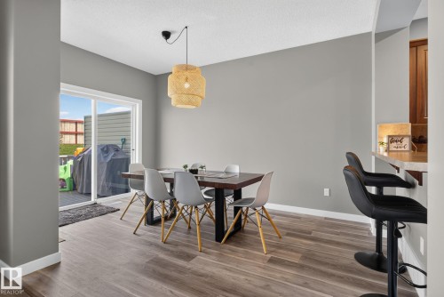 Dining area with wood-finish flooring, featuring a sliding glass door to an outdoor deck - 385 Simmonds Way, Leduc, AB - Indoor Photo Showing Dining Room