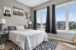 Room featuring light gray walls, wood-finish flooring, and a large window array - 