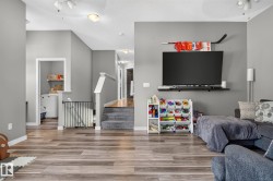 Open-concept living space with wood-finish flooring and neutral gray walls - 