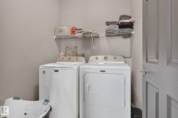 Dedicated laundry area featuring a wire storage shelf, light gray wall paint, and a paneled interior door with a brushed nickel handle - 