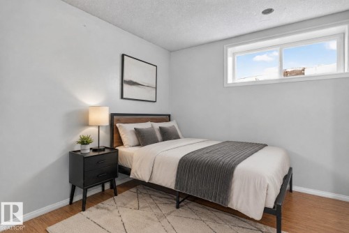Light-colored walls complementing wood-finish flooring - 385 Simmonds Way, Leduc, AB - Indoor Photo Showing Bedroom