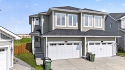 Modern duplex exterior featuring light green siding and white trim - 