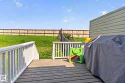 Expansive outdoor deck featuring wood-finish flooring and white railings - 