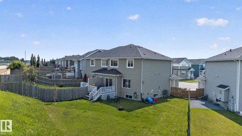 Rear exterior of a two-story residence with light gray siding and a dark shingle roof - 385 Simmonds Way, Leduc, AB - Outdoor