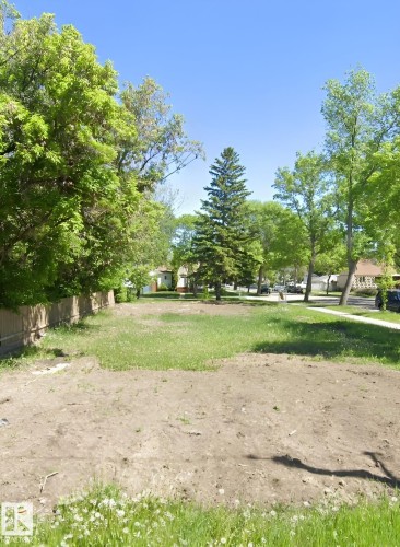 Expansive lot with partial grass coverage, mature perimeter trees, and a wooden fence - 10404 113 Avenue Nw, Edmonton, AB 