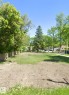 Expansive lot with partial grass coverage, mature perimeter trees, and a wooden fence - 10404 113 Avenue Nw, Edmonton, AB 