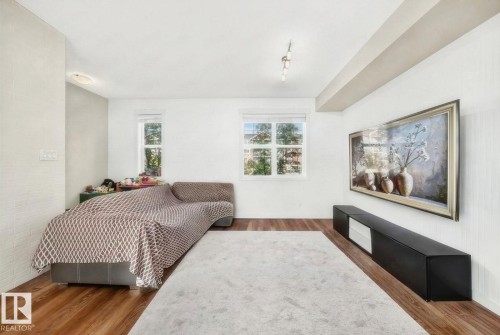 Hardwood-finish flooring, recessed lighting, track lighting, and two windows - #20 8315 180 Av Nw, Edmonton, AB 