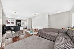 Wood-finish flooring throughout, with a dining area featuring a modern table and seating - 