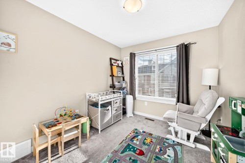 Neutral wall color, window with horizontal blinds, flush mount ceiling light, and carpeted flooring - #20 8315 180 Av Nw, Edmonton, AB 