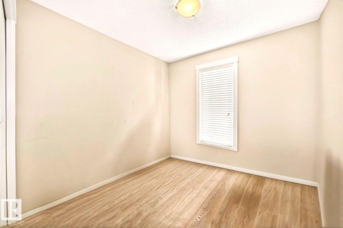 Wood-finish flooring with neutral wall tones and a window with blinds - #20 8315 180 Av Nw, Edmonton, AB 