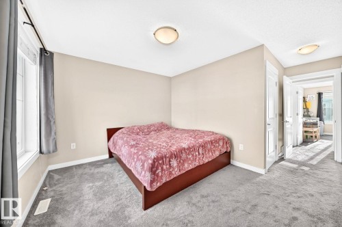 Neutral wall paint, light gray carpeting, a window with white trim, and flush mount lighting - #20 8315 180 Av Nw, Edmonton, AB 