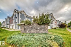 Stone facade with capstone accents, mature plantings, and manicured green spaces - 