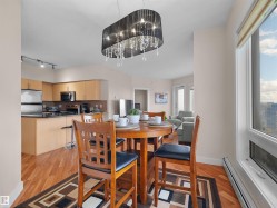 Wood-finish flooring, built-in kitchen cabinetry, stainless steel appliances, and a contemporary chandelier - 