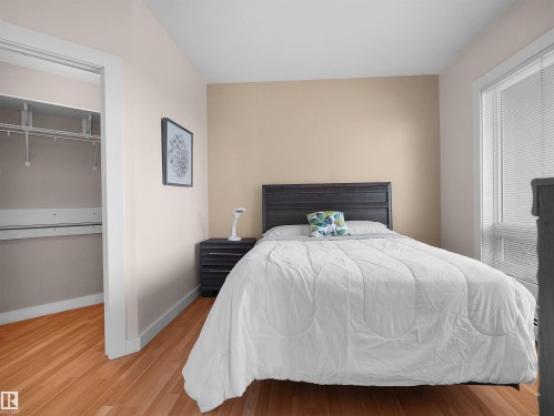 Hardwood flooring, painted walls, window with blinds, closet with wire shelving - #1601 10136 104 St Nw, Edmonton, AB 