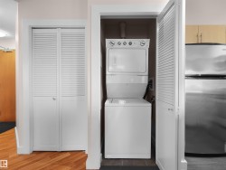 In-unit stacked washer and dryer, louvered closet doors, and wood-finish flooring - 