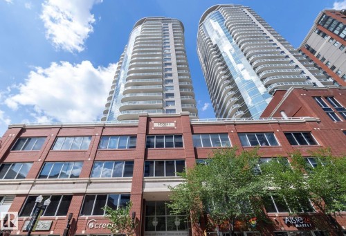 Modern high-rise residential buildings with multiple balconies, a brick facade base, and prominent storefront windows - #1601 10136 104 St Nw, Edmonton, AB 