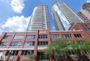 Modern high-rise residential buildings with multiple balconies, a brick facade base, and prominent storefront windows - #1601 10136 104 St Nw, Edmonton, AB 