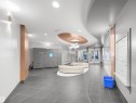 Lobby with gray large format tile flooring, curved white and copper ceiling design, and a modern chandelier - #1601 10136 104 St Nw, Edmonton, AB 