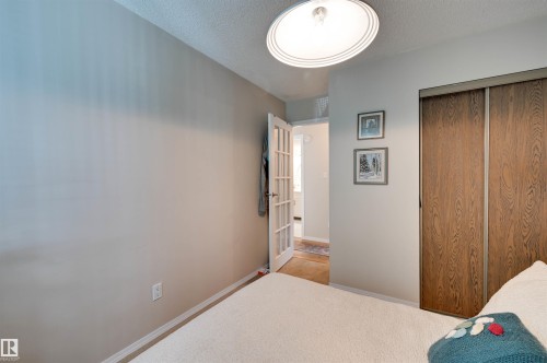 Recessed lighting, wood-finish sliding closet doors, and French doors with glass panels - #203 24 Alpine Pl, St. Albert, AB 