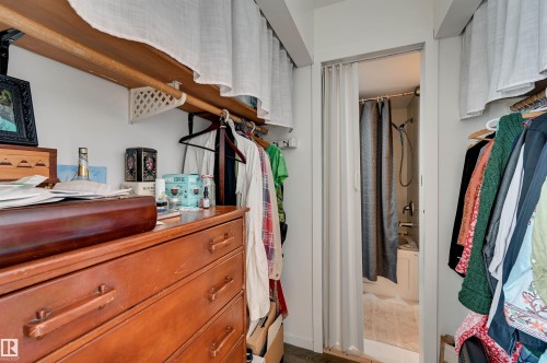 Built-in shelving with hanging rods and a folding door - #203 24 Alpine Pl, St. Albert, AB 