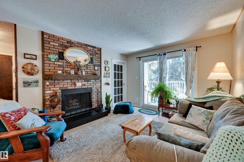 Brick-clad fireplace with a wood mantel - #203 24 Alpine Pl, St. Albert, AB 