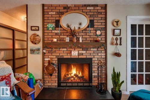Brick-clad fireplace with a wood mantel and hearth - #203 24 Alpine Pl, St. Albert, AB 