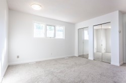 Recessed ceiling light fixture, neutral carpet, white walls, and dual mirrored closet doors - 