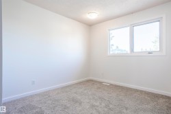 White painted walls, white trim, grey carpeting, a single window, and a flush-mount ceiling light - 