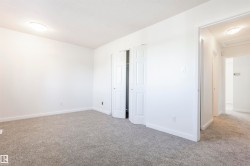 Neutral tone wall paint, grey carpet flooring, white trim, and bi-fold closet doors - 