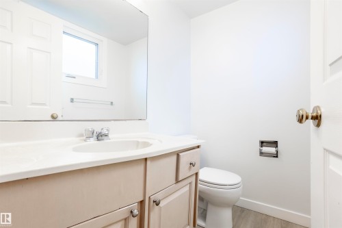 Light-toned vanity with integrated sink, chrome faucet, and expansive wall mirror - 17927 80 Avenue Nw, Edmonton, AB 
