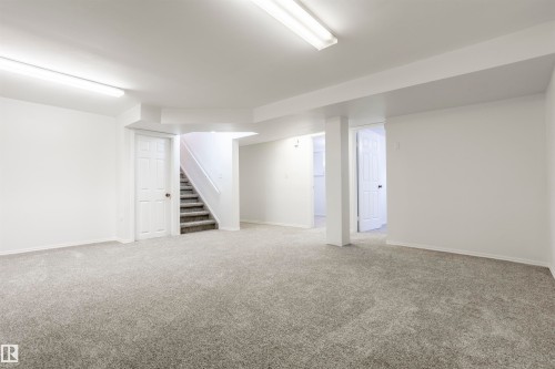 Spacious area with light gray carpeting, white walls, and bright overhead lighting - 17927 80 Avenue Nw, Edmonton, AB 
