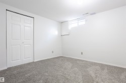 Neutral wall tones with gray carpeting, featuring a bi-fold closet door and a high-set window - 