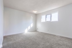 Neutral wall paint, gray carpeting, and a flush-mount ceiling light - 