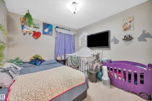 Neutral wall paint with carpet flooring, mounted ceiling light fixture, and window with solid curtains - 15017 26 Street Nw, Edmonton, AB 