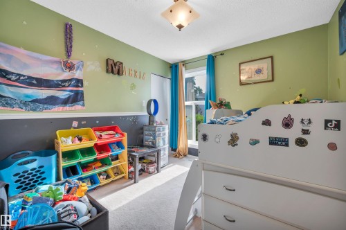 Carpeted flooring, painted walls with a chair rail, window with drapes, and a ceiling-mounted light fixture - 15017 26 Street Nw, Edmonton, AB 