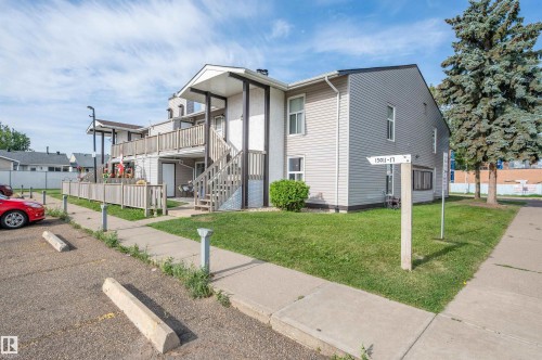 Multi-story building with light-toned siding and white trim - 15017 26 Street Nw, Edmonton, AB 