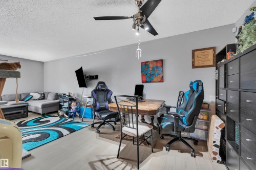 Recessed ceiling with an overhead ceiling fan, light-toned wood-finish flooring, and light gray wall paint - 15017 26 Street Nw, Edmonton, AB 