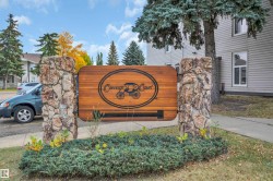 Stone and wood-finish entry sign with established landscaping - 