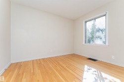 Hardwood flooring, light neutral wall tones, and a window with white trim - 