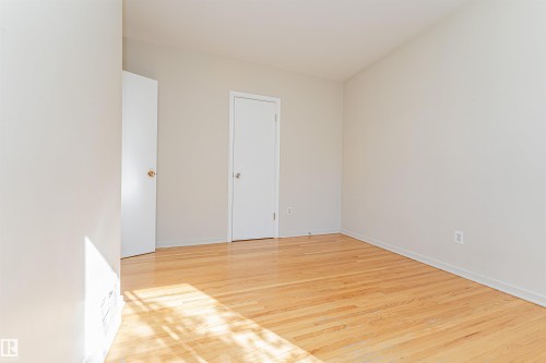 Hardwood-finish flooring, light-toned walls, and multiple entryways - 8743 Strathearn Drive Nw, Edmonton, AB 