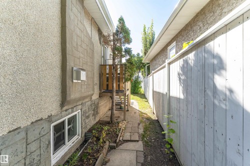 Stone patio walkway leading to a wood deck with railings - 8743 Strathearn Drive Nw, Edmonton, AB 