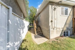 Exterior stucco finish with a white privacy fence and a wooden staircase - 