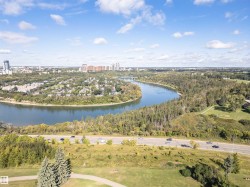 Riverfront setting with a surrounding urban landscape, mature trees, and a developed roadway - 