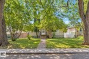 Manicured front lawn with mature trees and a brick-finish pathway leading to the entrance - 8743 Strathearn Drive Nw, Edmonton, AB 