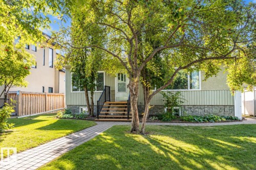Light green exterior siding with a stone-clad foundation - 8743 Strathearn Drive Nw, Edmonton, AB 