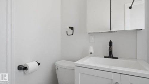 White vanity with integrated sink, bronze-finish faucet, and coordinating wall-mounted storage cabinet - 11836 62 Street Nw, Edmonton, AB 