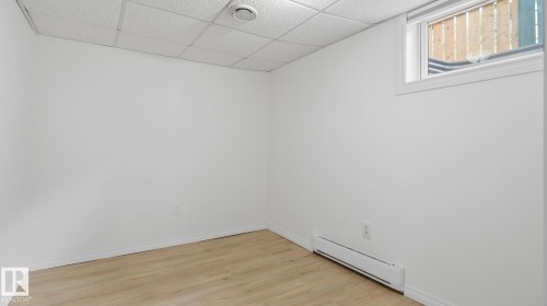 Recessed window with white trim, wood-finish flooring, white walls, and a drop-panel ceiling - 11836 62 Street Nw, Edmonton, AB 